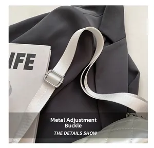 Detail of silver hardware adjustment buckle and white fabric strap on quilted bag