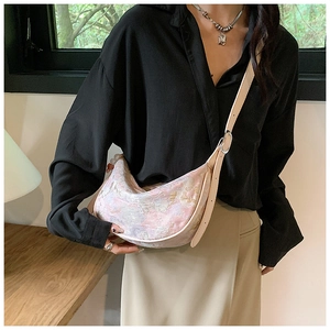Detail of floral jacquard crescent bag with adjustable cream leather shoulder strap