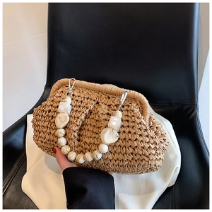 Detail of woven straw handbag featuring marble acrylic beaded handle and metal frame clasp