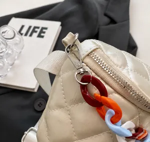 Detail of silver metal hook and colorful acrylic decorative chain on quilted bag