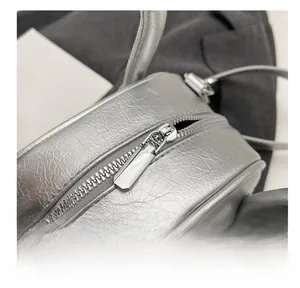 Close-up of the smooth metal zipper on this silver lychee texture leather handbag