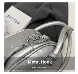 Close-up of shiny silver metallic bag featuring premium hardware hooks and round handle