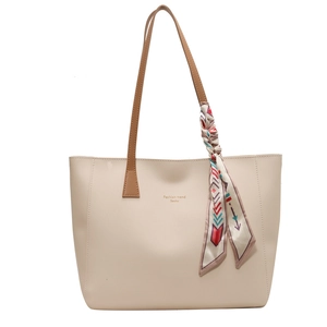 Large beige tote bag with brown straps and floral silk scarf detail for commute