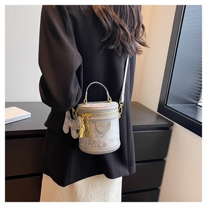 Detail of light gray bucket bag with gold hardware, chain pendant and elephant charm