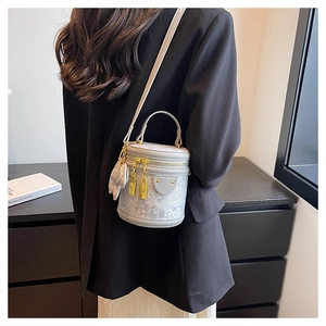 Detailed back view of a mini cylindrical bucket bag worn by a model in a black suit
