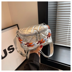 Close-up of silver quilted chest bag with colorful plastic chains and double zippers