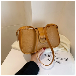 Detail der braunen Schultertasche aus genarbtem Leder mit D-Ring-Schnalle