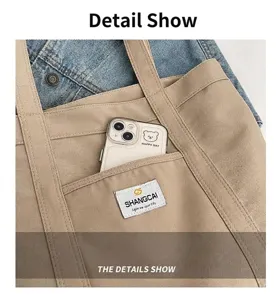 Primer plano del bolsillo delantero de un bolso tote de lona beige con etiqueta tejida