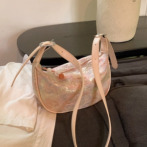 Pink crescent shoulder bag with embossed texture and adjustable cream leather strap