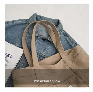 Detalle de bolso tote de lona caqui con asas anchas y cómodas y etiqueta tejida minimalista