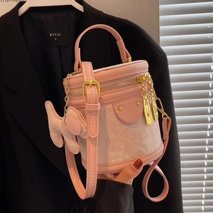 Pink leather bucket bag with white jacquard fabric and cute dog pendant accessory