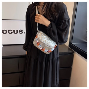 Detail of silver quilted crossbody bag featuring vibrant colorful chunky chain accent