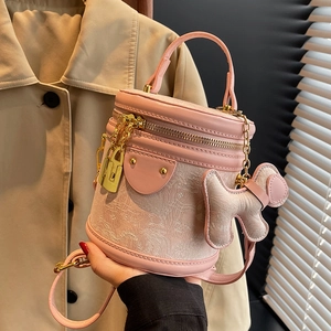 Pink cylinder bucket bag in jacquard fabric with dog charm and gold hardware