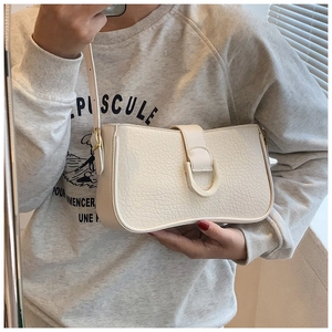 Detailansicht einer cremeweißen Schultertasche mit Rissleder-Struktur und D-Ring-Schnalle