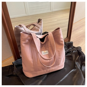 Close-up of pink canvas tote bag showing the exterior pocket and SHANGCAI brand tag