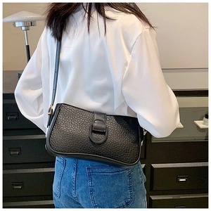 Detailansicht der schwarzen Schultertasche aus strukturiertem Leder mit D-Ring-Verschluss