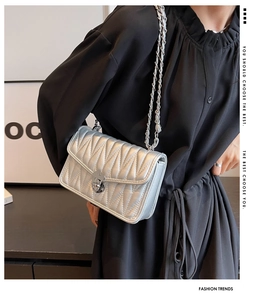 Close-up of silver quilted crossbody bag with metallic finish and chain strap
