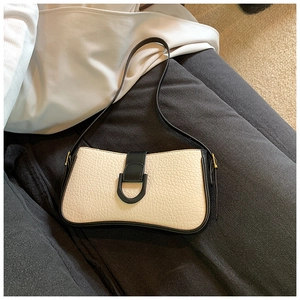 Detail der vintage Schultertasche in Beige und Schwarz mit Kieseltextur und D-Schnalle