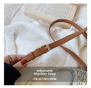 Λεπτομέρεια ρυθμιζόμενου καφέ δερμάτινου ιμάντα ώμου με μεταλλική αγκράφα σε πλεκτή τσάντα