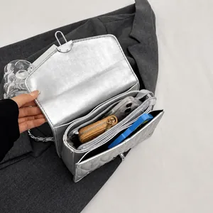 Internal view of silver quilted chain bag showing multi-compartment storage capacity