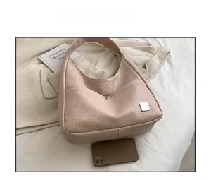 Detailed top view of a beige leather tote bag with phone for size comparison