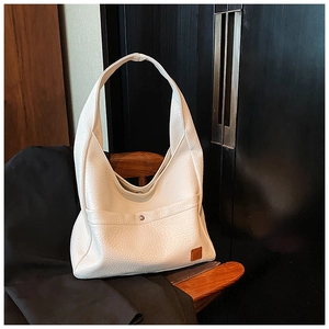 Detail of white lychee leather hobo bag showing texture, wide strap and magnetic closure