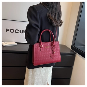 Détail du sac cabas en PU rouge matelassé avec charme de cœur et texte doré chic