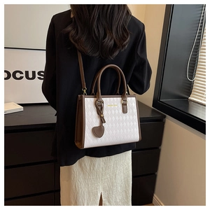 Détail du grand sac cabas avec motif matelassé marron et breloque en forme de cœur