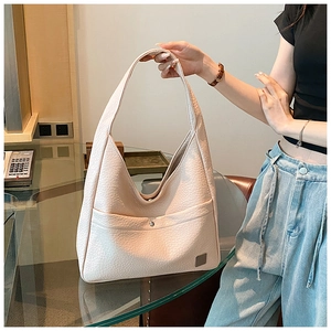 Close-up of a light pink pebbled leather hobo bag with wide strap and magnetic pocket