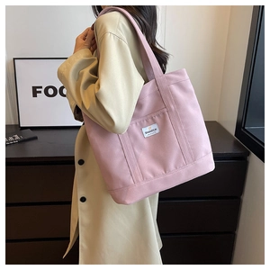 Detail of pink canvas tote bag with shoulder strap and SHANGCAI logo label for daily use