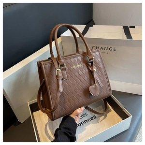 Vue détaillée du sac cabas matelassé marron avec lettrage doré et breloque en cœur