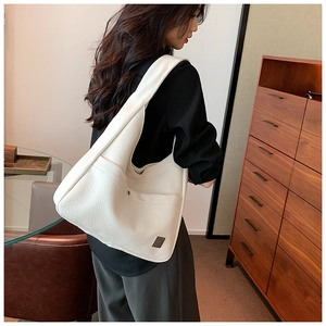 Detail of the high-quality white lychee leather texture and metal trim on the tote bag