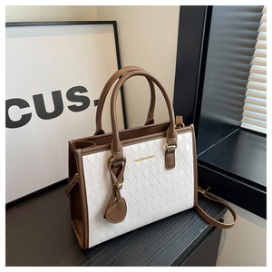 Détail du sac cabas bicolore avec texture en treillis diamant et finitions dorées