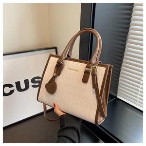 Vue détaillée du sac cabas beige et marron avec motif matelassé et accessoire cœur