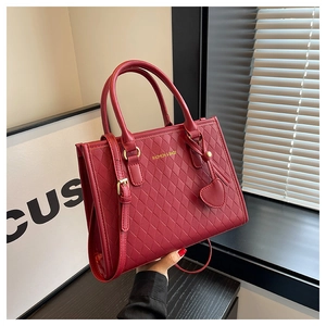 Détail du sac cabas rouge en similicuir matelassé avec pendentif coeur et logo doré