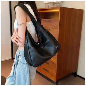 Detail of black large capacity hobo bag with pebble grain faux leather and wide strap