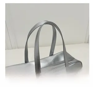 Close-up of metallic silver tote bag with shiny mirror finish and embossed brand logo