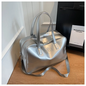 Detail of silver metallic tote bag with embossed NOCO logo and adjustable shoulder strap