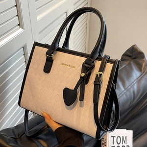 Sac fourre-tout contrasté beige et noir avec motif matelassé et pendentif en cœur