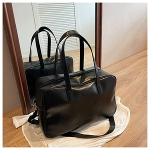 Detail of the high-quality glossy black PU leather travel bag showing the NOCO logo