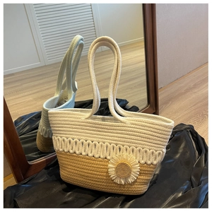 Detail of hand-woven tote bag featuring a 3D daisy flower and textured cream-khaki contrast