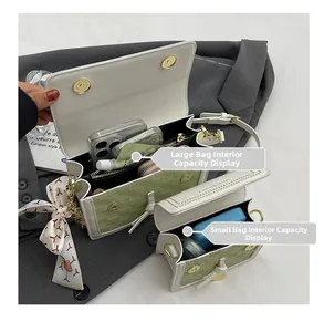 Capacità interna della borsa intrecciata verde con tasca e sciarpa di seta decorativa