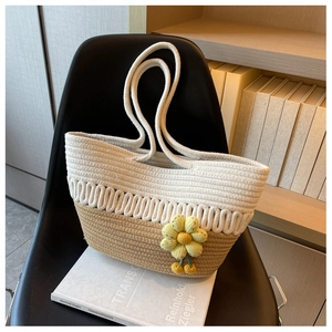 Detail of woven tote bag with bicolor拼接, wave texture, and yellow flower charm