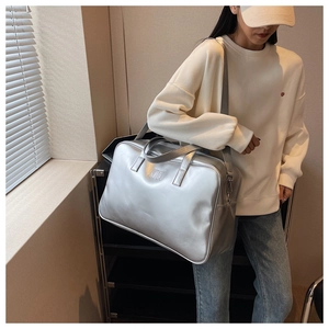 Detail of silver metallic PU leather bag with embossed NOCC logo and adjustable shoulder strap