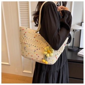 Detailed close-up of woven tote bag with colorful polka dots and a yellow daisy charm