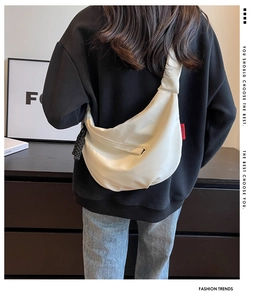 Sac bandoulière demi-lune en nylon blanc porté sur un sweat à capuche noir oversize