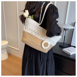 Detail of woven tote bag with a white daisy flower accent and contrast rope stripes
