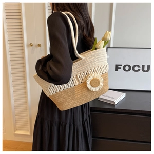 Detail of hand-woven tote bag with khaki stitching and decorative white daisy flower