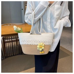 Detail of hand-woven tote bag with two-tone stitching, wave texture and yellow flower charm