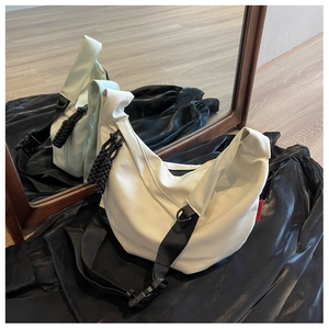 Détail du sac croissant en nylon blanc avec bandoulière ajustable et étiquette rouge